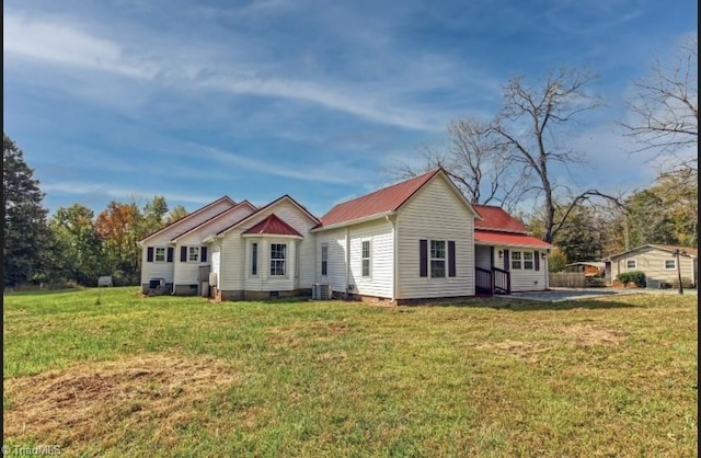 back of house featuring central AC unit and a lawn