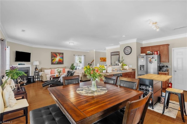 3502 Quarry Ct, High Point, NC 27265 - dining space featuring crown molding, wood finished floors, and a fireplace