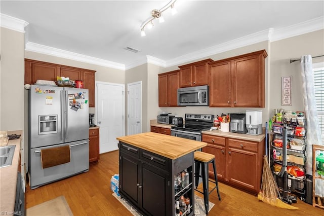 3502 Quarry Ct, High Point, NC 27265 - kitchen featuring appliances with stainless steel finishes, wooden counters, light wood-type flooring, ornamental molding, and dark cabinets