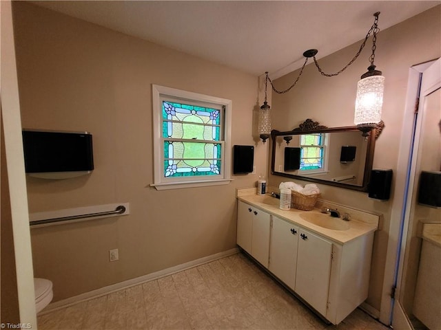 bathroom featuring vanity, toilet, and plenty of natural light