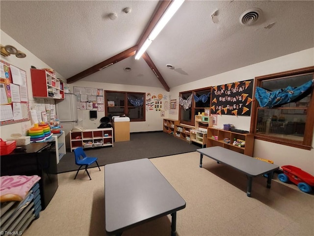 game room featuring a textured ceiling, vaulted ceiling with beams, and track lighting