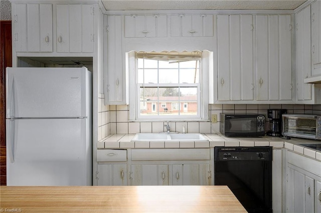 kitchen featuring a toaster, a sink, tile countertops, and black appliances