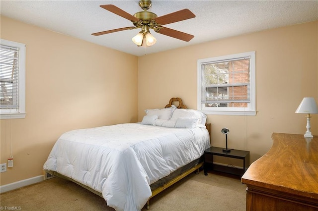 bedroom with a textured ceiling, carpet, a ceiling fan, and baseboards