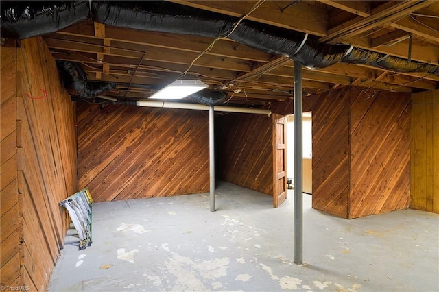 unfinished below grade area featuring wood walls