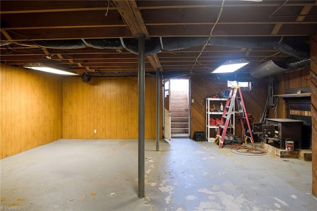 unfinished basement featuring electric panel and wooden walls