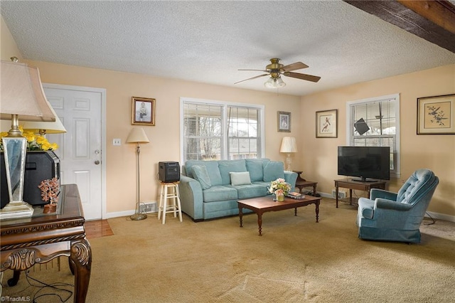 carpeted living area featuring a textured ceiling, baseboards, and a ceiling fan