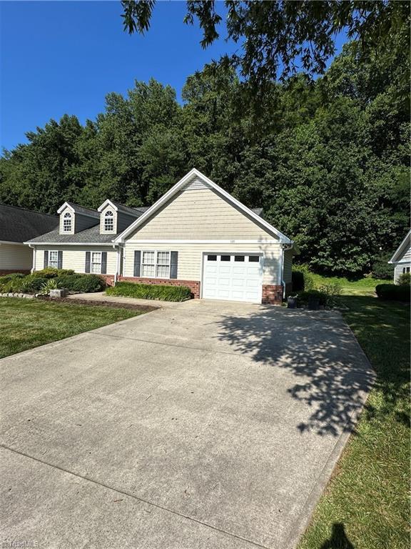 135 Plantation Place Ln, Mount Airy, NC 27030 - view of front of home with driveway, a front lawn, an attached garage, and brick siding