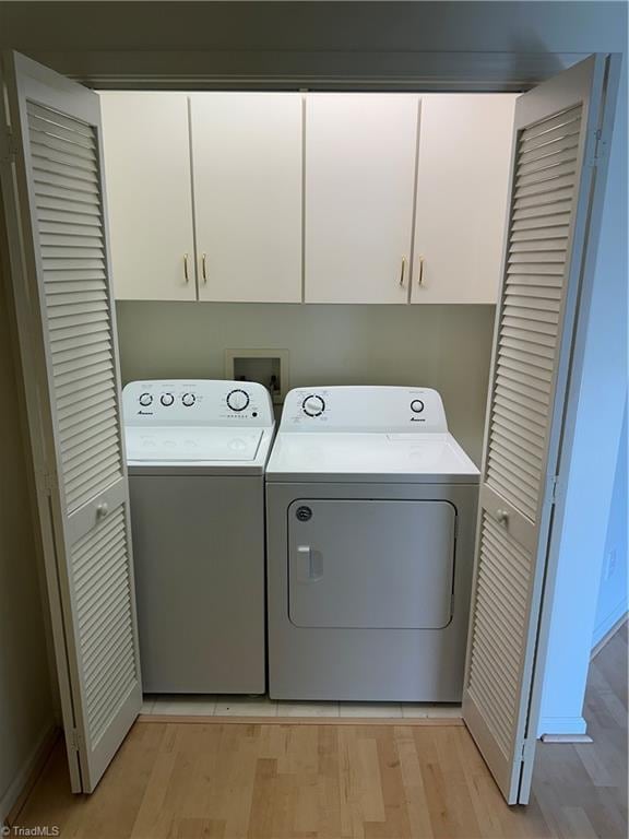 135 Plantation Place Ln, Mount Airy, NC 27030 - laundry room with washing machine and clothes dryer, cabinet space, and light wood-type flooring