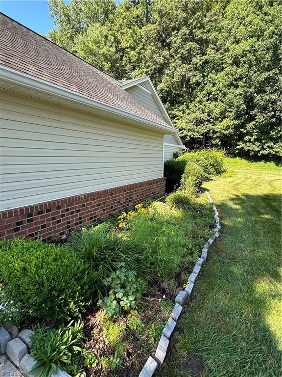 135 Plantation Place Ln, Mount Airy, NC 27030 - view of side of property with a yard, roof with shingles, and brick siding