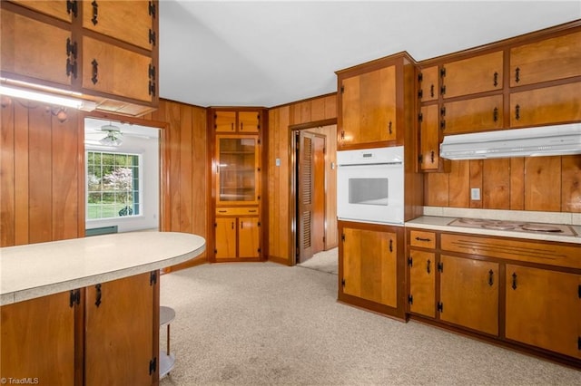 520 S Bunker Hill Rd, Colfax, NC 27235 - kitchen featuring white appliances, under cabinet range hood, wooden walls, light countertops, and brown cabinets
