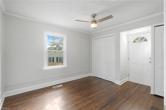 1908 Hilldale Dr, Burlington, NC 27215 - unfurnished bedroom featuring multiple windows, dark wood-style flooring, a closet, crown molding, and ceiling fan