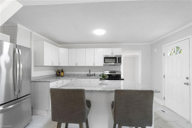 1908 Hilldale Dr, Burlington, NC 27215 - kitchen featuring stainless steel appliances, light marble finish floors, crown molding, a kitchen breakfast bar, and white cabinetry