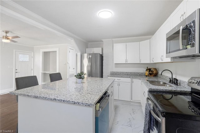 1908 Hilldale Dr, Burlington, NC 27215 - kitchen featuring stainless steel appliances, crown molding, a kitchen island, white cabinetry, and light stone counters
