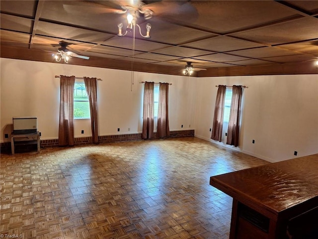 spare room with a ceiling fan, coffered ceiling, and baseboards