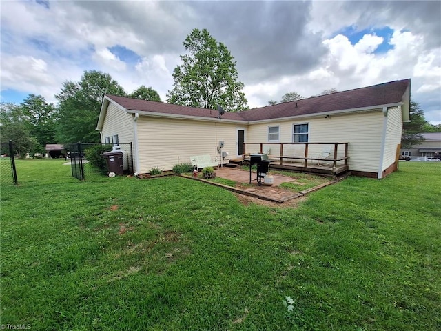 back of property with a yard, a patio area, and a deck