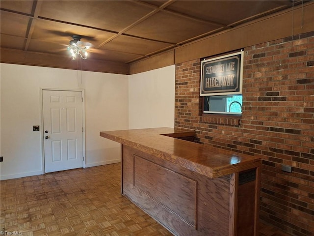 indoor dry bar with a ceiling fan and baseboards