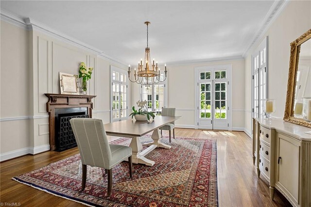 dining space featuring an inviting chandelier, crown molding, and hardwood / wood-style floors