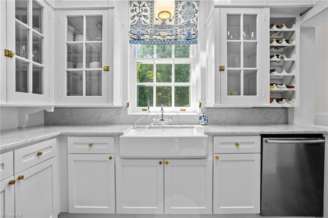 kitchen featuring dishwasher, light stone countertops, and white cabinetry