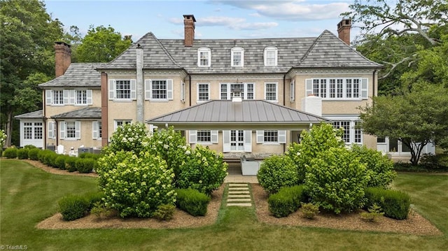 rear view of property with a lawn