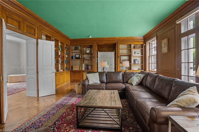 living room featuring light parquet floors, built in shelves, and ornamental molding