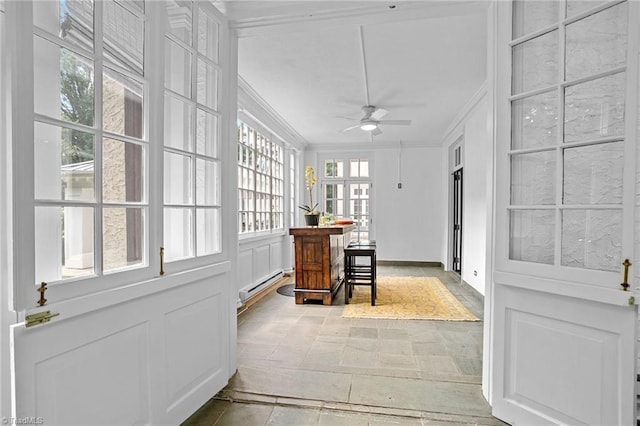 sunroom featuring a baseboard radiator and ceiling fan