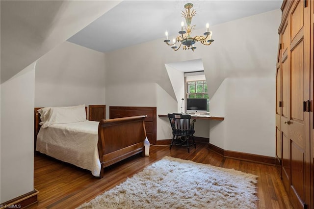 bedroom featuring dark wood-type flooring, vaulted ceiling, and a chandelier