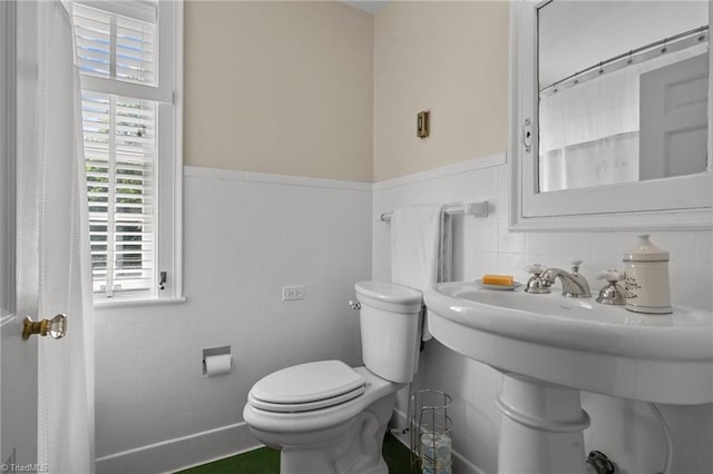 bathroom with decorative backsplash, tile walls, and toilet