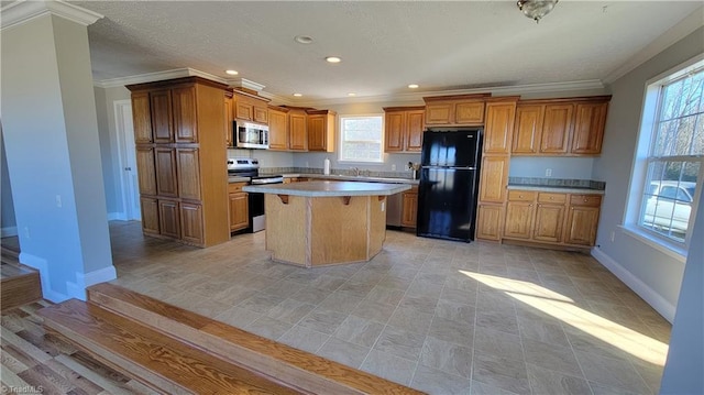 kitchen with appliances with stainless steel finishes, ornamental molding, sink, a center island, and a breakfast bar area