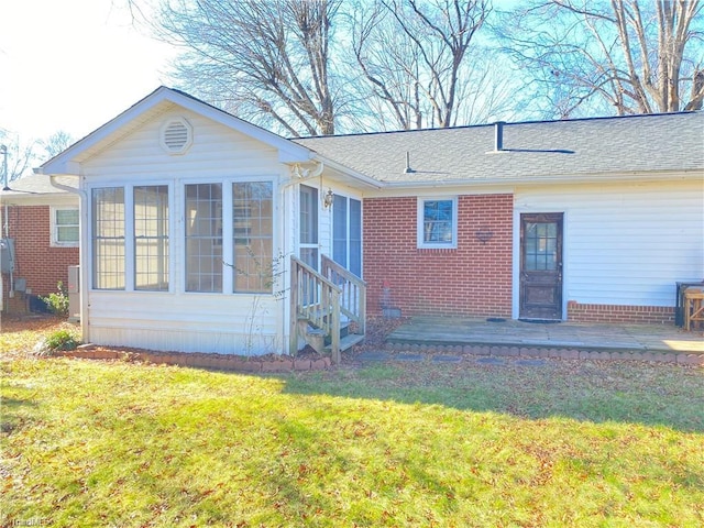 rear view of house featuring a sunroom, a patio area, and a yard