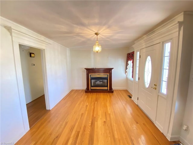 entryway featuring light wood-type flooring and a notable chandelier