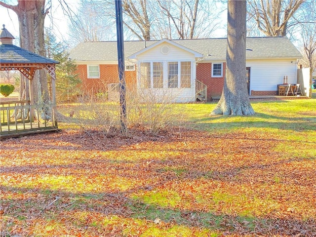 back of house with a gazebo and a yard