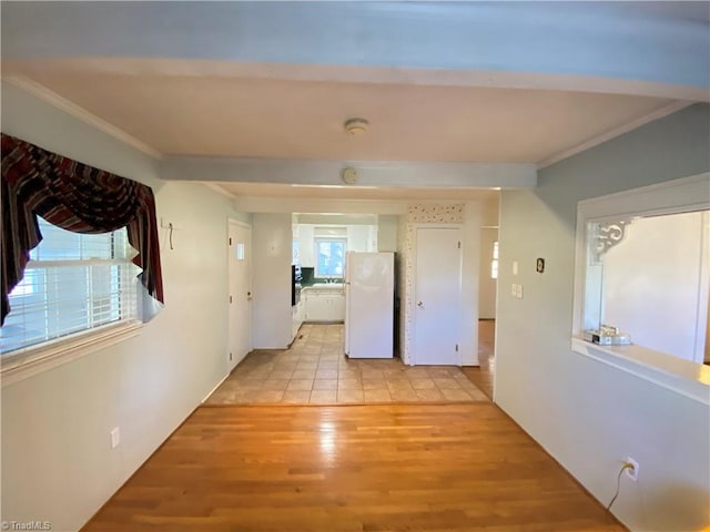 corridor with beam ceiling, light hardwood / wood-style floors, and crown molding