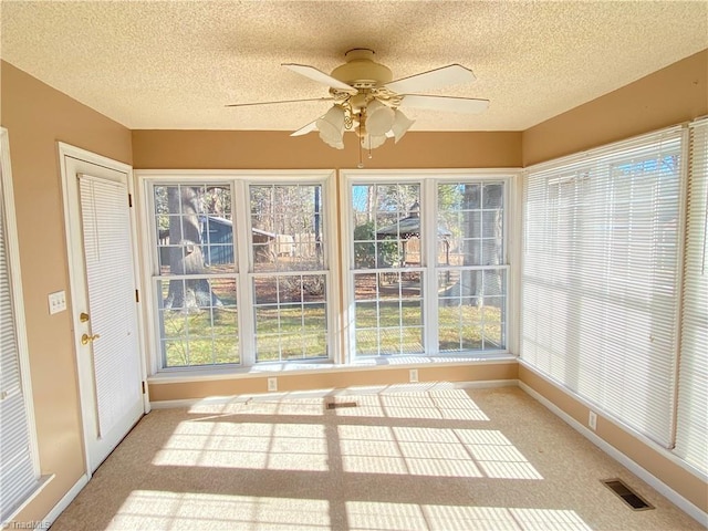 unfurnished sunroom featuring ceiling fan