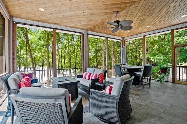 sunroom / solarium featuring wood ceiling, ceiling fan, and lofted ceiling