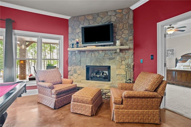 sitting room with ornamental molding and a stone fireplace