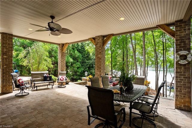 view of patio featuring an outdoor living space, ceiling fan, and a water view