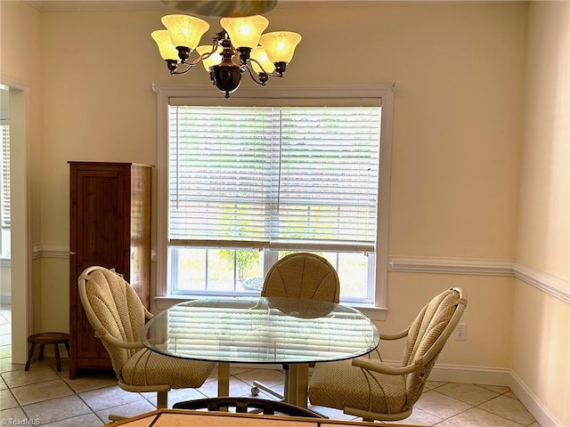 dining room with crown molding, baseboards, light tile patterned flooring, and a notable chandelier