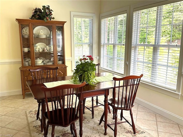 dining space with baseboards, plenty of natural light, and light tile patterned flooring