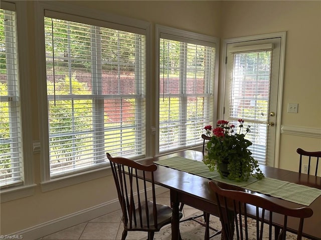 dining area with tile patterned flooring, baseboards, and a healthy amount of sunlight