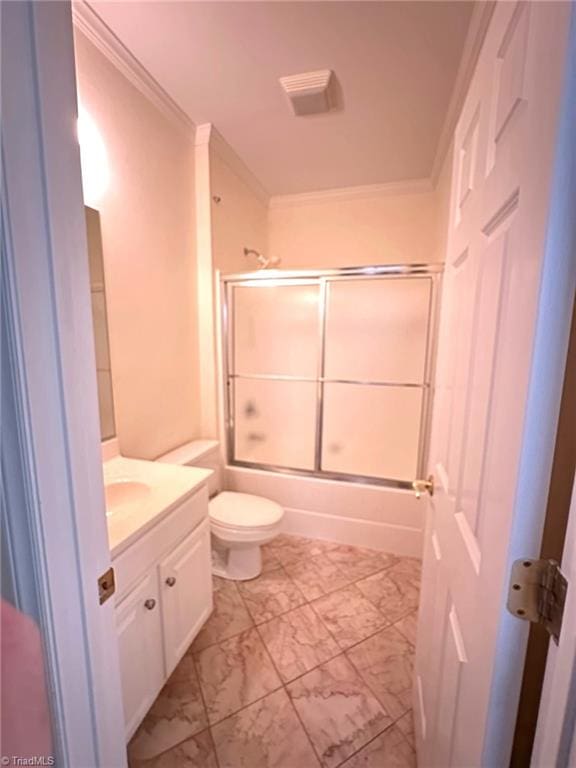 bathroom featuring enclosed tub / shower combo, vanity, toilet, marble finish floor, and ornamental molding