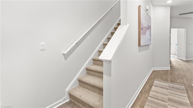 staircase with hardwood / wood-style flooring