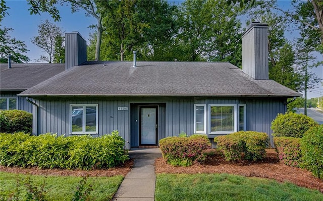 view of front of property with a chimney, a shingled roof, and board and batten siding