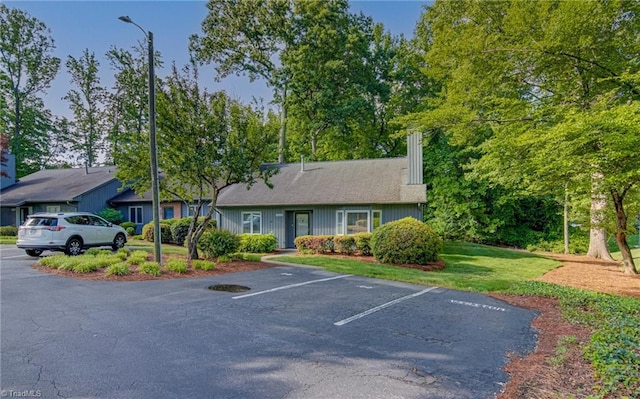 view of front of property featuring uncovered parking and a chimney
