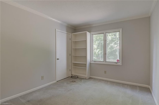unfurnished bedroom featuring light colored carpet, baseboards, crown molding, and a textured ceiling