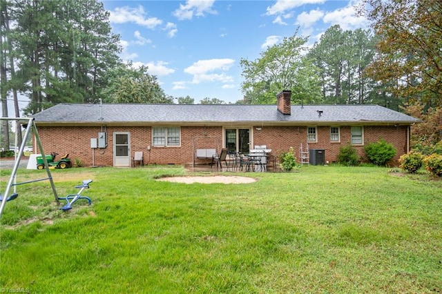 back of property with central AC unit, a yard, and a patio