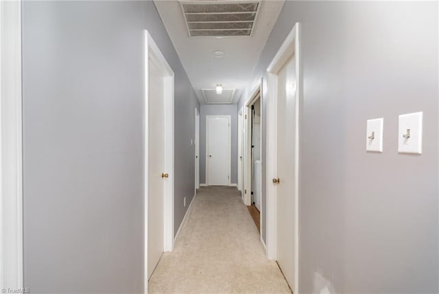 hallway featuring light colored carpet