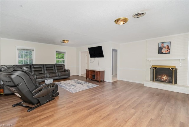 living room featuring light hardwood / wood-style floors and a brick fireplace