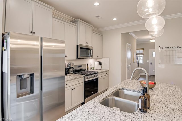 kitchen with visible vents, crown molding, appliances with stainless steel finishes, and a sink