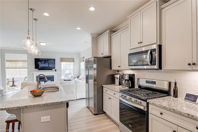 kitchen featuring tasteful backsplash, a kitchen breakfast bar, open floor plan, stainless steel appliances, and a sink