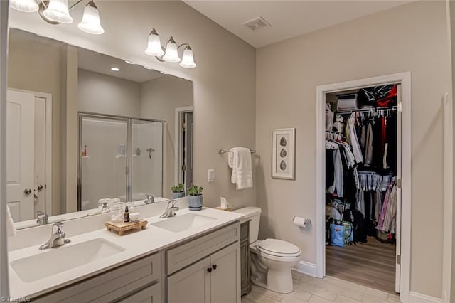 bathroom with double vanity, a stall shower, a sink, and visible vents